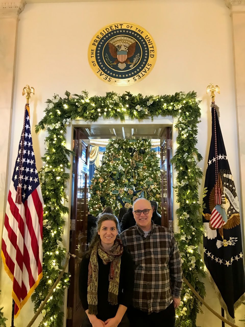 Kristin and Ricky standing under the White House Seal
