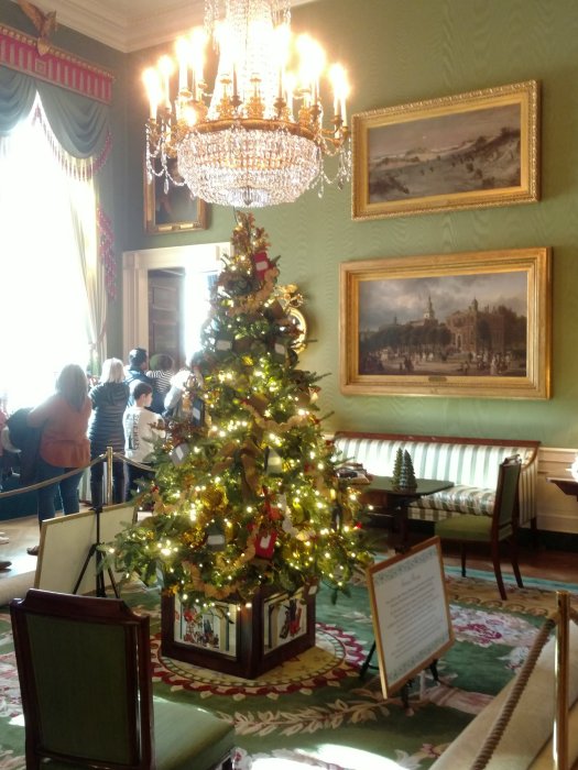 Christmas trees with white lights line a hallway at the White house
